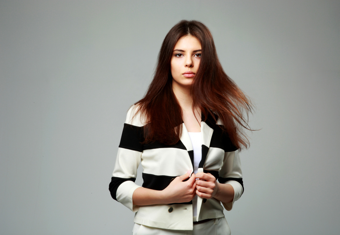Portrait of a young beautiful woman in casual clothes on gray background