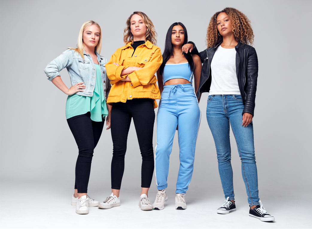 Studio Shot Of Young Independent Multi-Cultural Female Friends Looking Into Camera